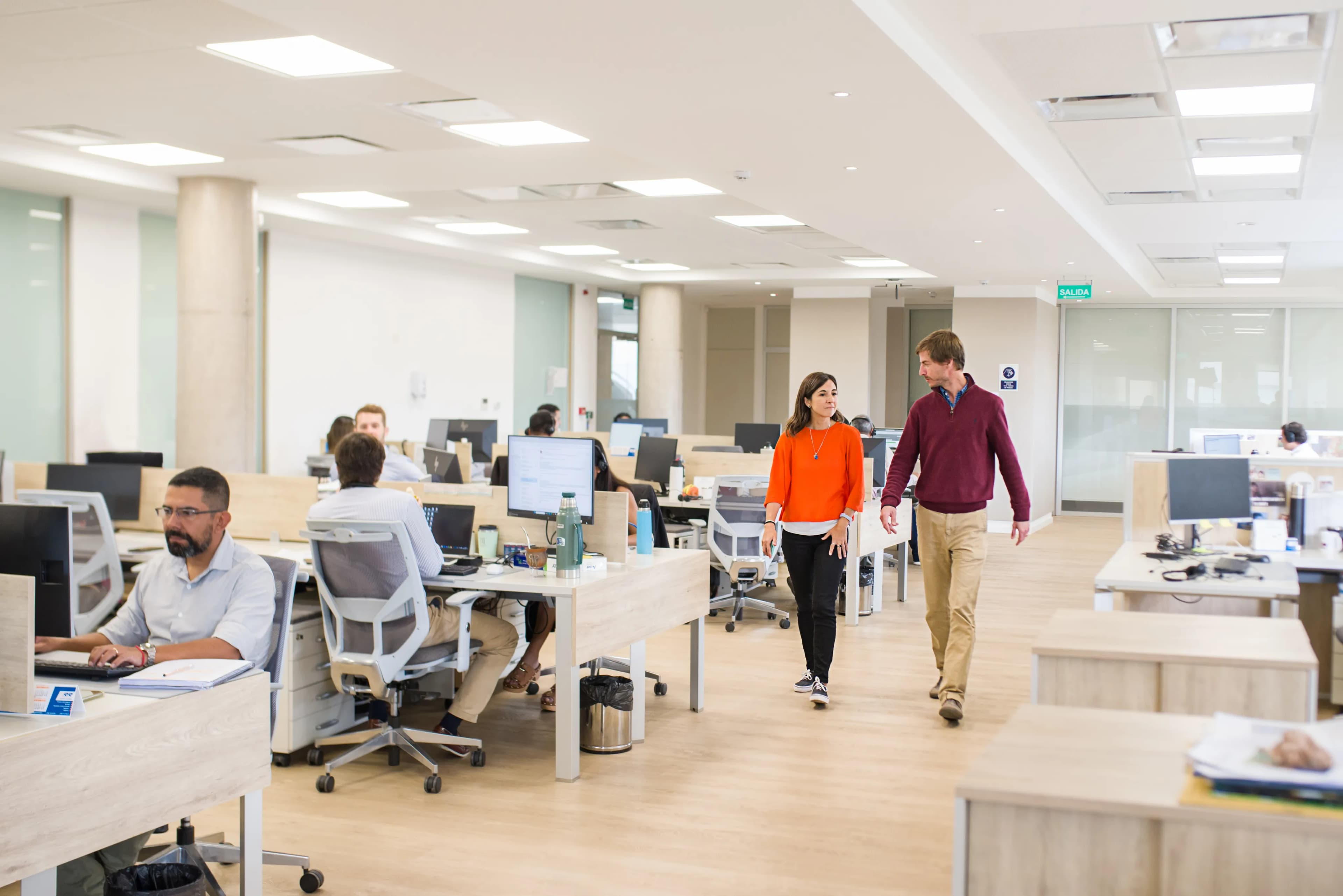 Dos personas caminando dentro de una oficina